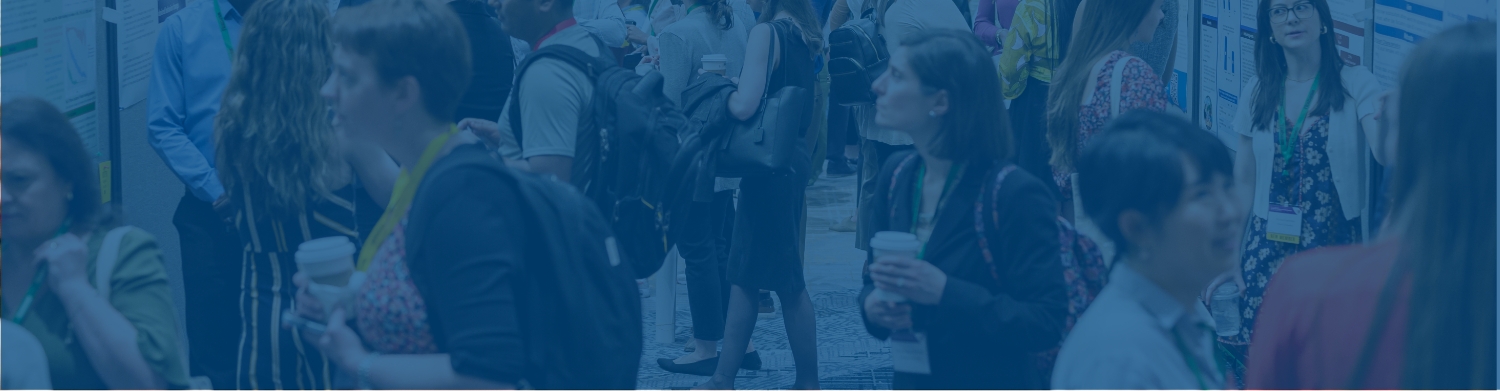 Professionals at an event, carrying backpacks and coffee and wearing conference badges
