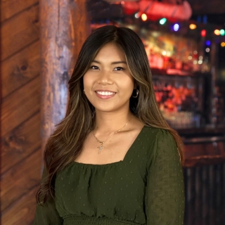 The author standing in front of a log cabin with soft, warm lighting