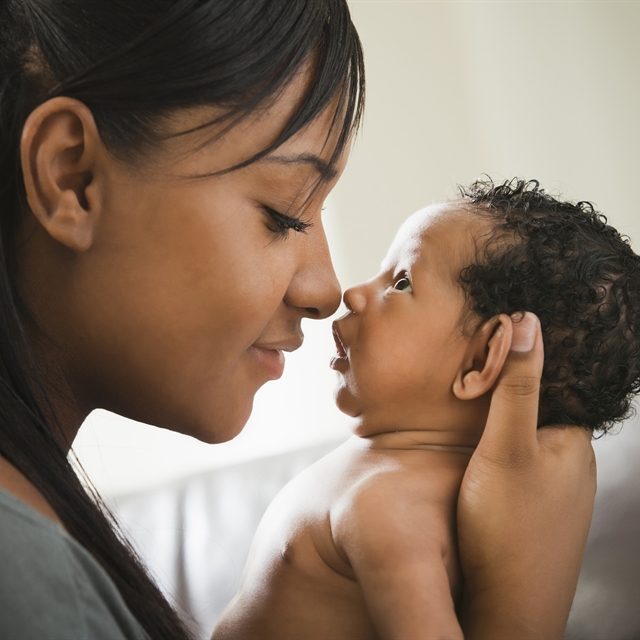 Woman smiling at a baby and holding it close