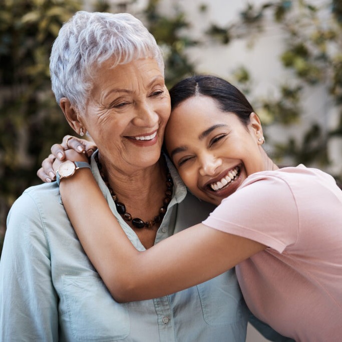 Two women smiling and hugging