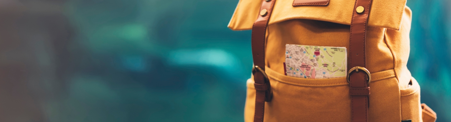 yellow backpack with a map sticking out of a pocket